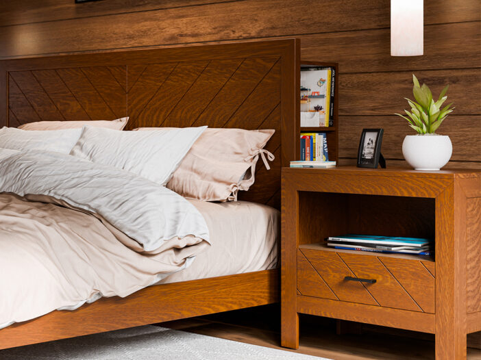 Cozy bedroom scene featuring a wooden bed frame with a chevron pattern headboard and matching nightstand. The bed is dressed in beige and white bedding, and the nightstand holds books, a small framed photo, and a potted plant. The warm wooden tones create a rich, inviting ambiance.