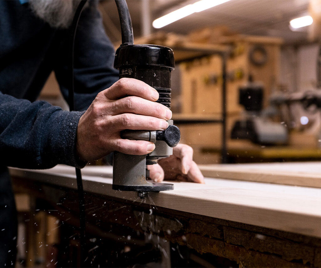Craftsman routing solid wood for Amish quality furniture.